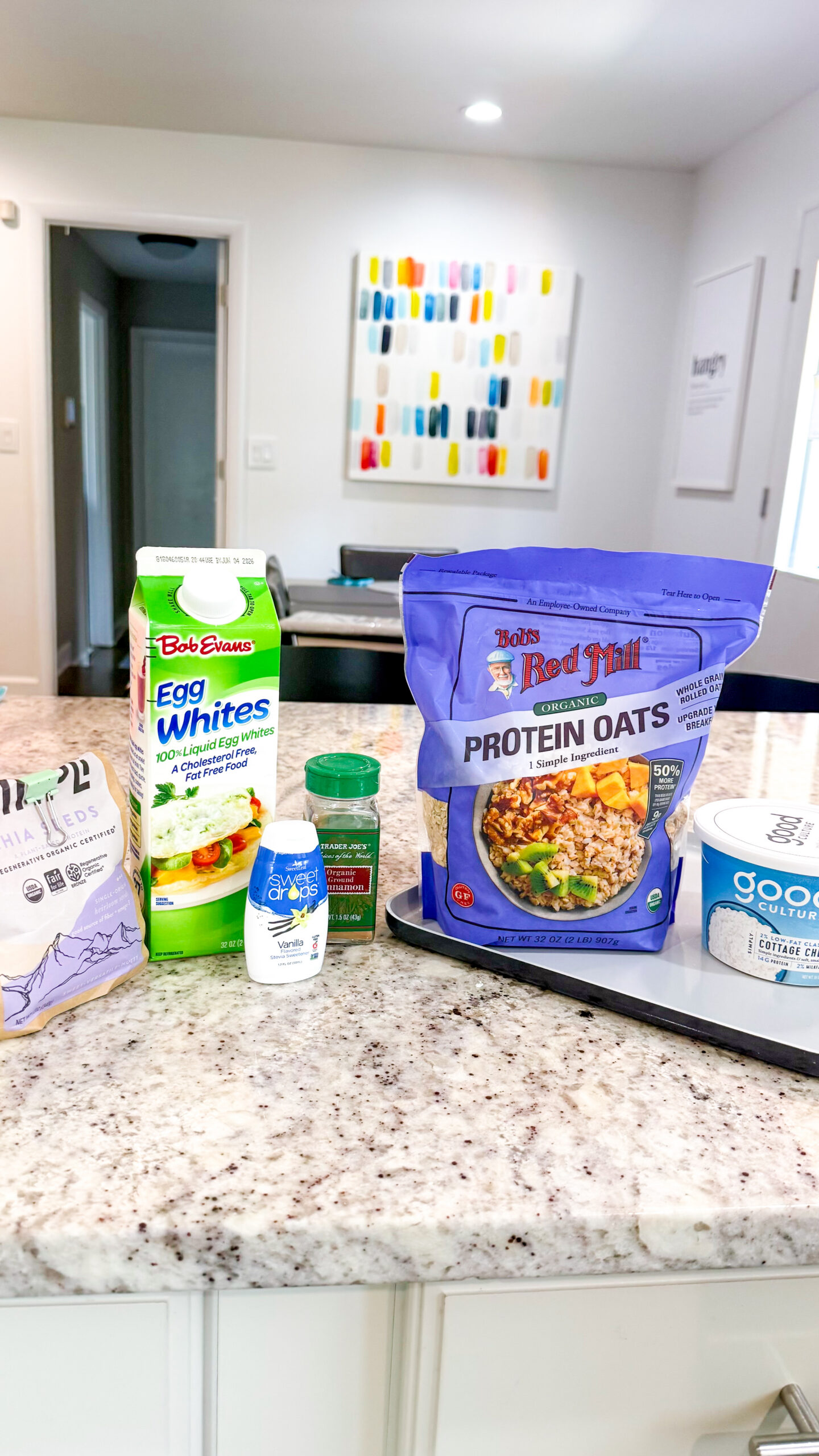 Ingredients for Trader Joe's protein pancake dupe (protein oats, egg whites, cottage cheese, chia seeds, cinnamon, and vanilla drops)